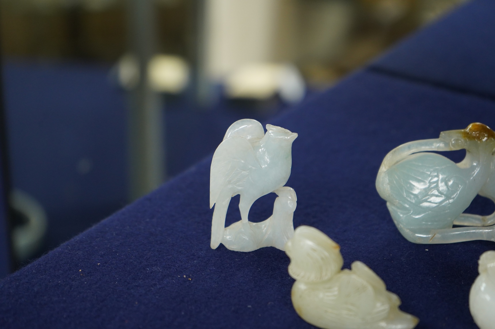 A Chinese jade figure of a Mandarin duck and a miniature pot and cover, three jadeite carvings and a bowenite dragon, 16.5cm